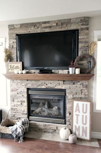 tv on mantel with decor on either side