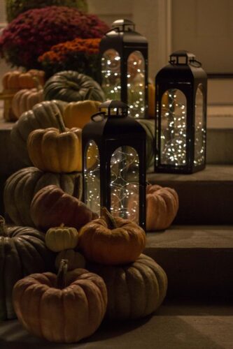 pumpkins on porch steps with candles and lights
