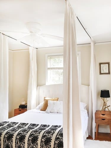 master bedroom bed with white fabric canopy