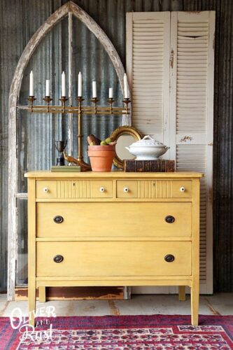 mustard yellow dresser with books on top