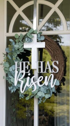 wreath on door with cross and he is risen